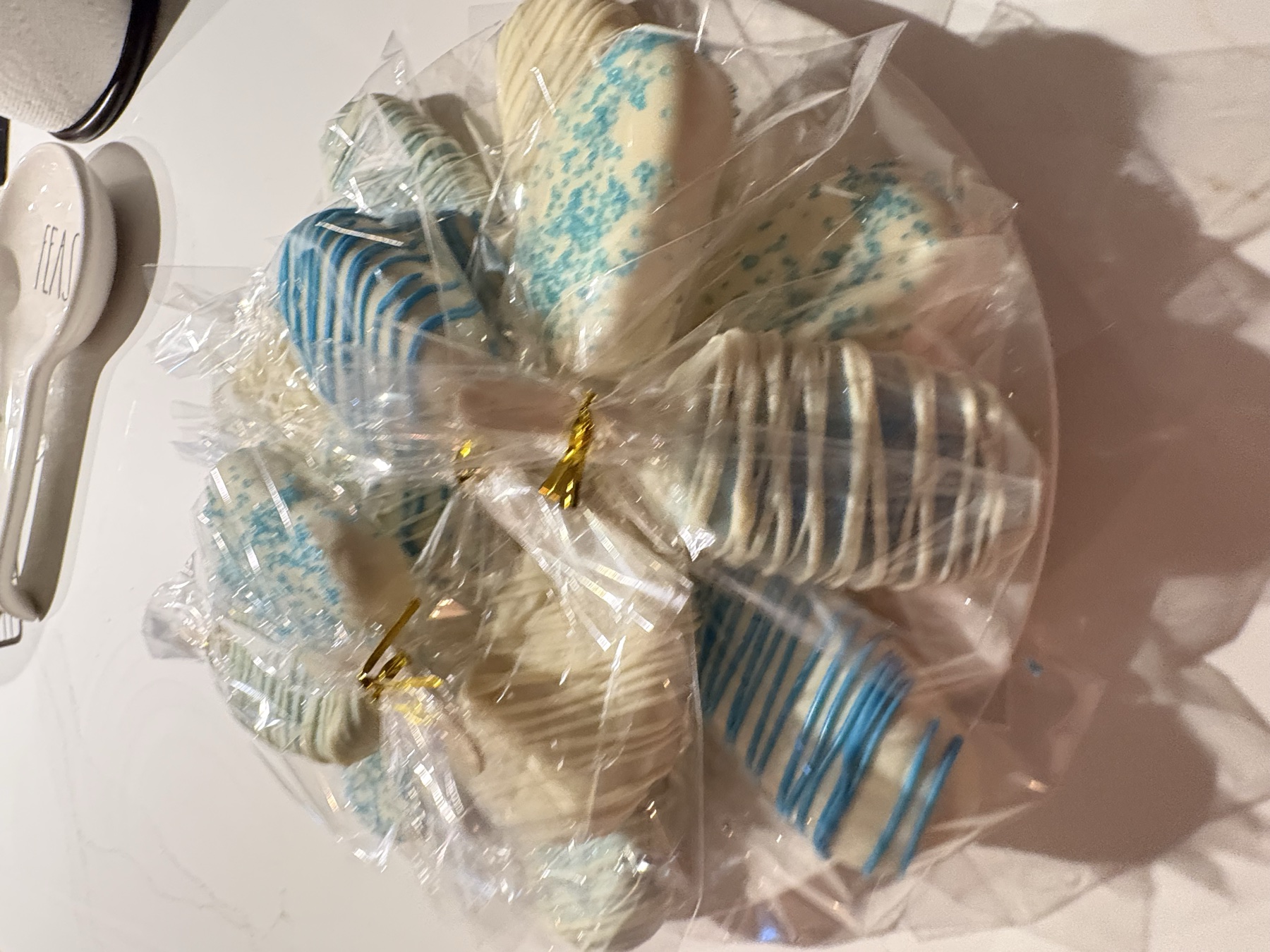 A party tray filled with individually wrapped blue and white cake pops